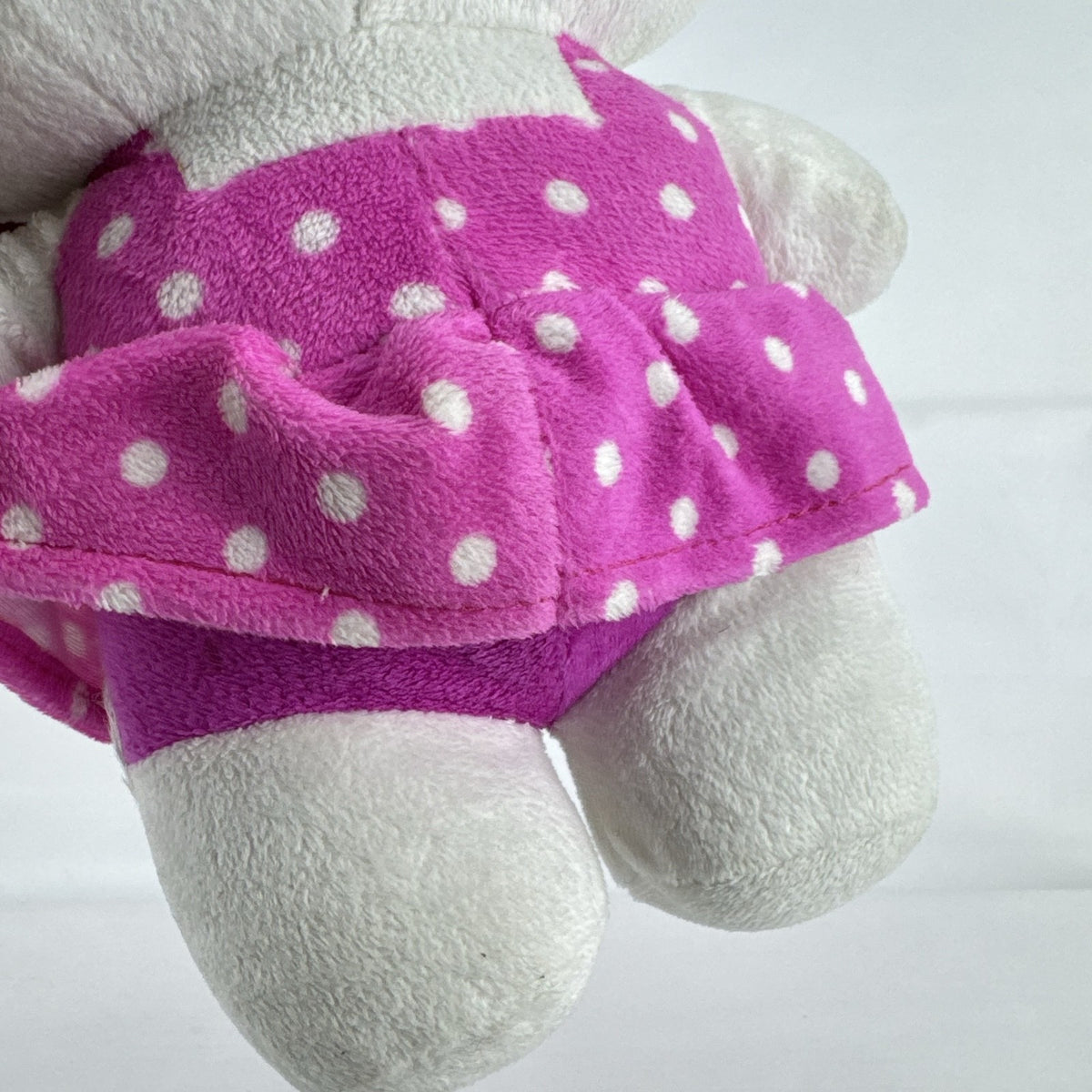 Sanrio 11-inch Hello Kitty plush wearing a pink polka dot dress with a purple flower