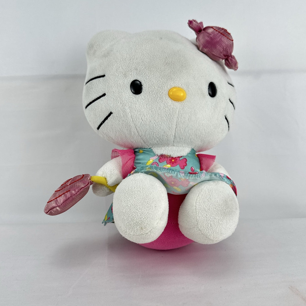 Sanrio Hello Kitty 9-inch plush doll wearing a teal candy print satin dress and holding a pink swirl lollipop.