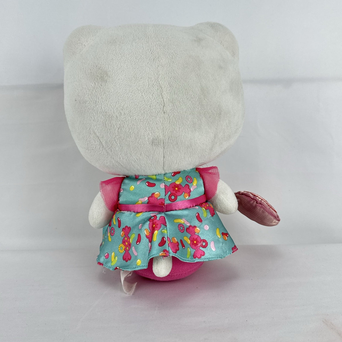 Sanrio Hello Kitty 9-inch plush doll wearing a teal candy print satin dress and holding a pink swirl lollipop.