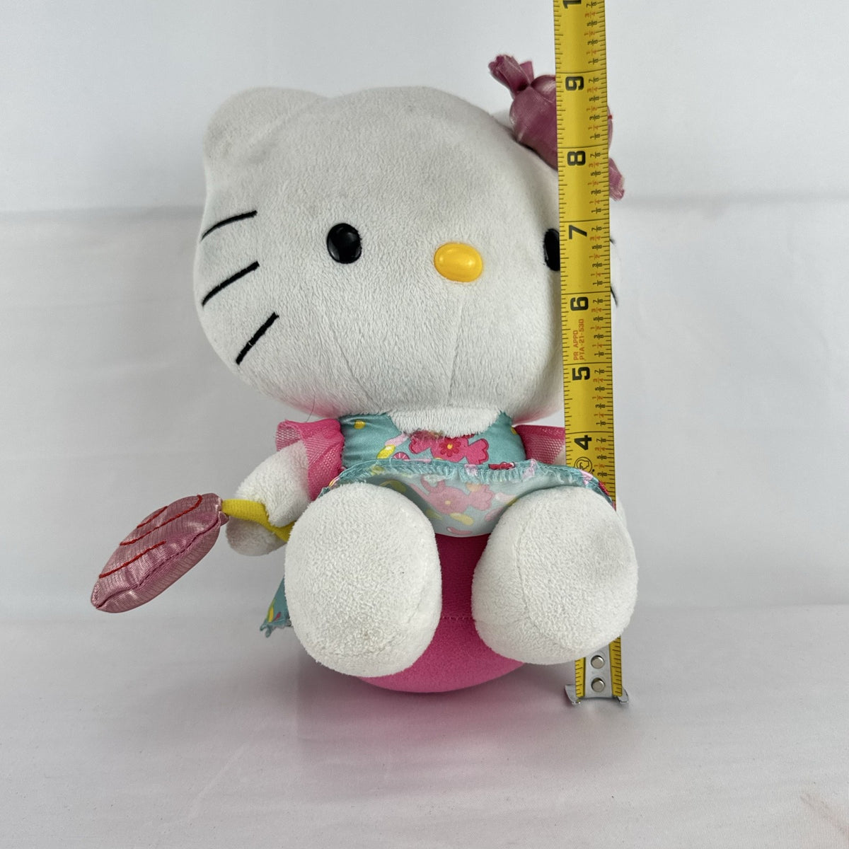 Sanrio Hello Kitty 9-inch plush doll wearing a teal candy print satin dress and holding a pink swirl lollipop.