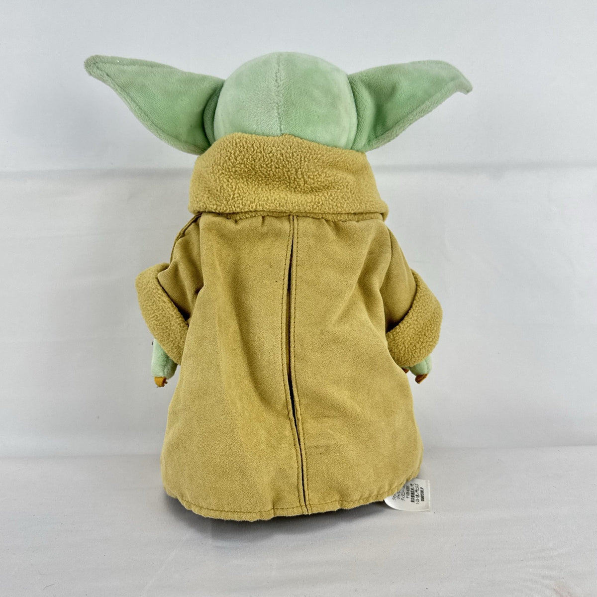 Disney Store 11-inch Grogu plush doll wearing a tan faux-suede coat with fleece trim