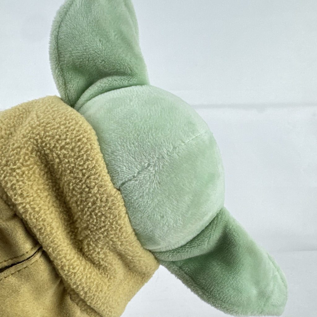 Disney Store 11-inch Grogu plush doll wearing a tan faux-suede coat with fleece trim