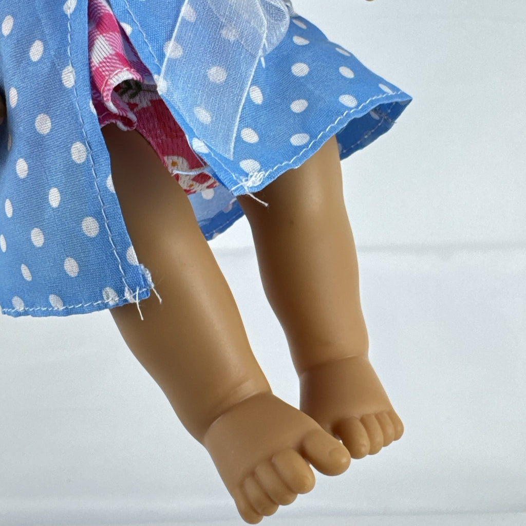 Hasbro Baby Alive 11-inch vinyl baby doll with molded brown hair, brown eyes, and blue polka dot dress
