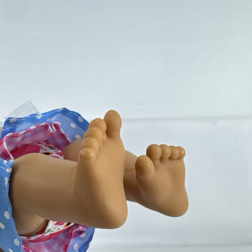 Hasbro Baby Alive 11-inch vinyl baby doll with molded brown hair, brown eyes, and blue polka dot dress