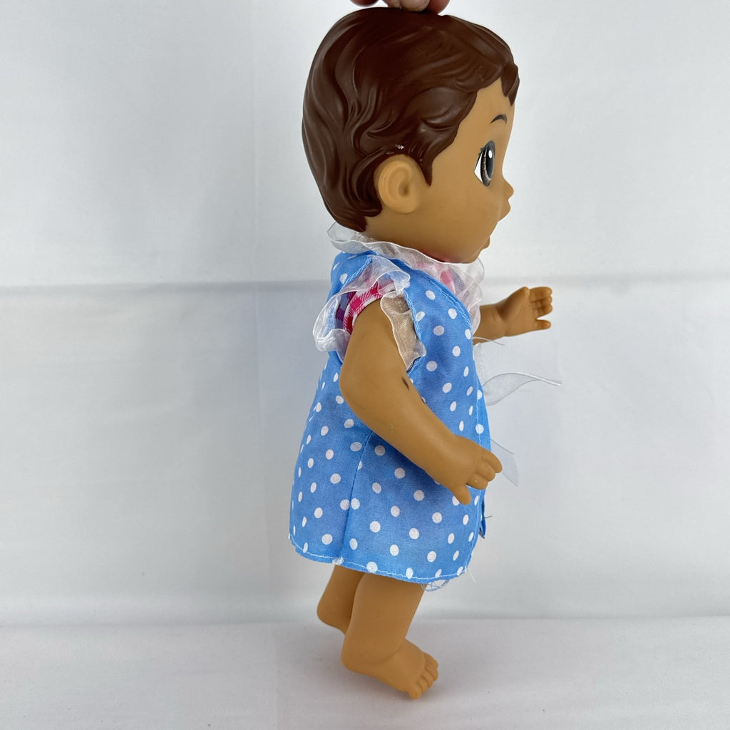 Hasbro Baby Alive 11-inch vinyl baby doll with molded brown hair, brown eyes, and blue polka dot dress