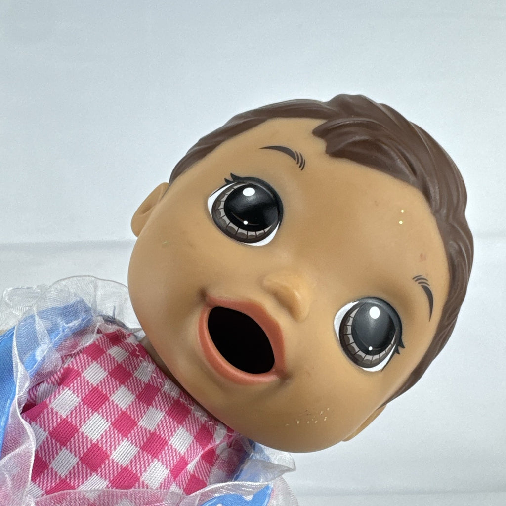 Hasbro Baby Alive 11-inch vinyl baby doll with molded brown hair, brown eyes, and blue polka dot dress