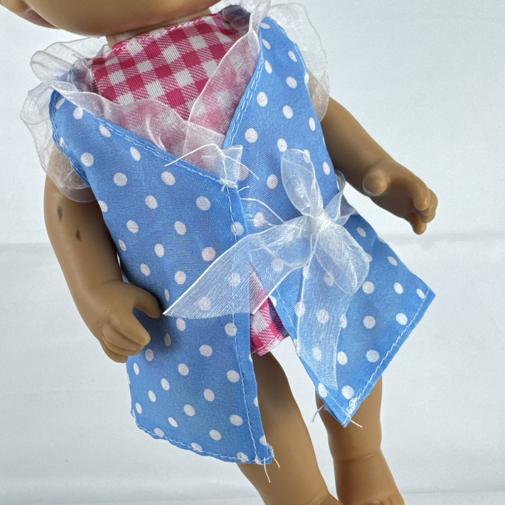 Hasbro Baby Alive 11-inch vinyl baby doll with molded brown hair, brown eyes, and blue polka dot dress