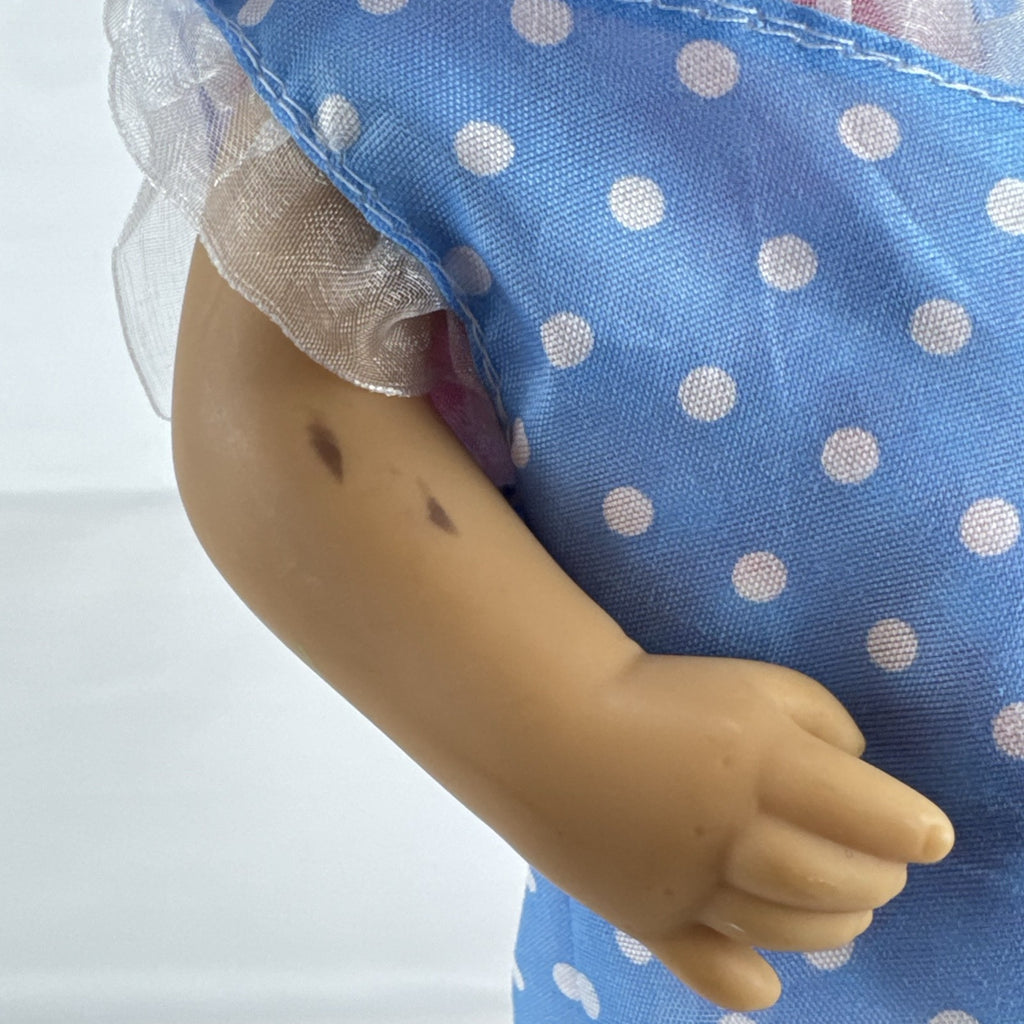 Hasbro Baby Alive 11-inch vinyl baby doll with molded brown hair, brown eyes, and blue polka dot dress