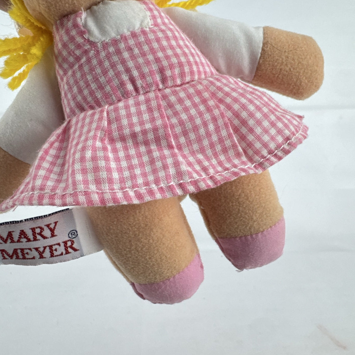 Mary Meyer 7-inch plush rag doll with yellow yarn pigtails and pink gingham dress