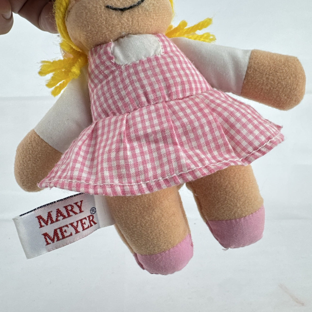Mary Meyer 7-inch plush rag doll with yellow yarn pigtails and pink gingham dress