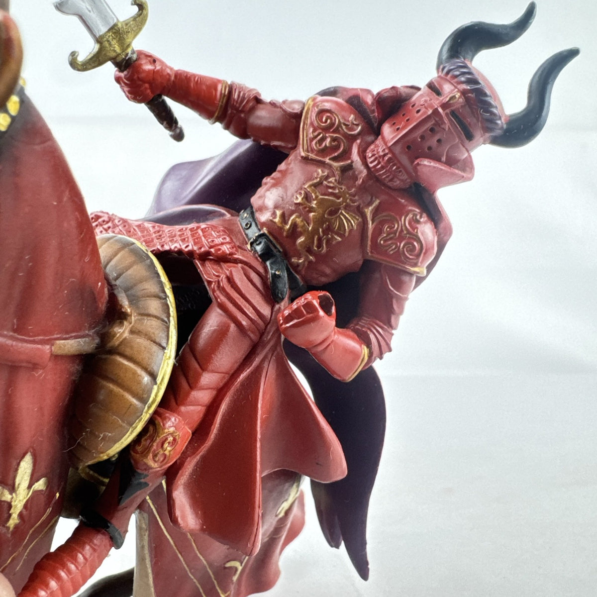 Papo red horned knight holding sword mounted on a Schleich crimson fleur-de-lis barded war horse