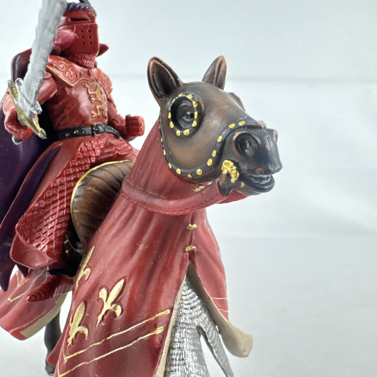 Papo red horned knight holding sword mounted on a Schleich crimson fleur-de-lis barded war horse