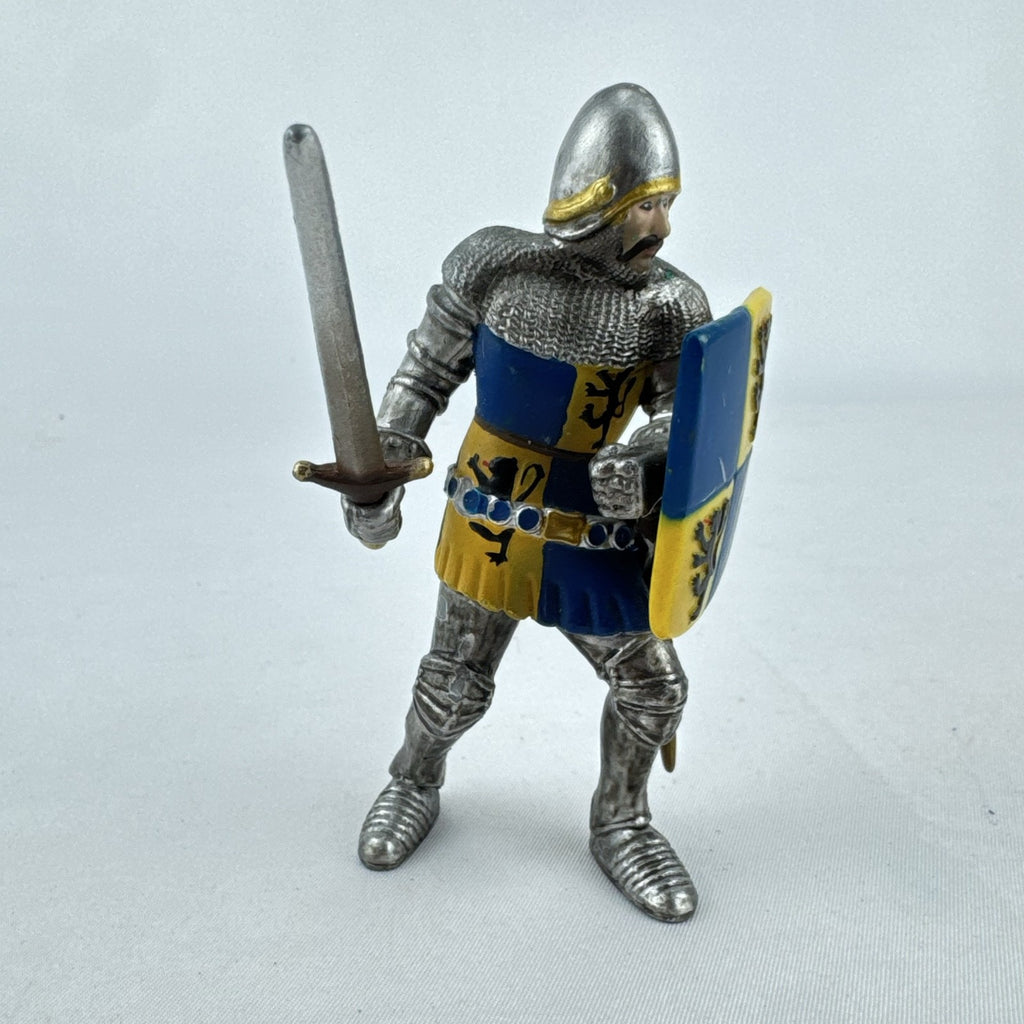 Schleich 2003 medieval knight foot soldier plastic figure holding a sword and blue and yellow lion shield