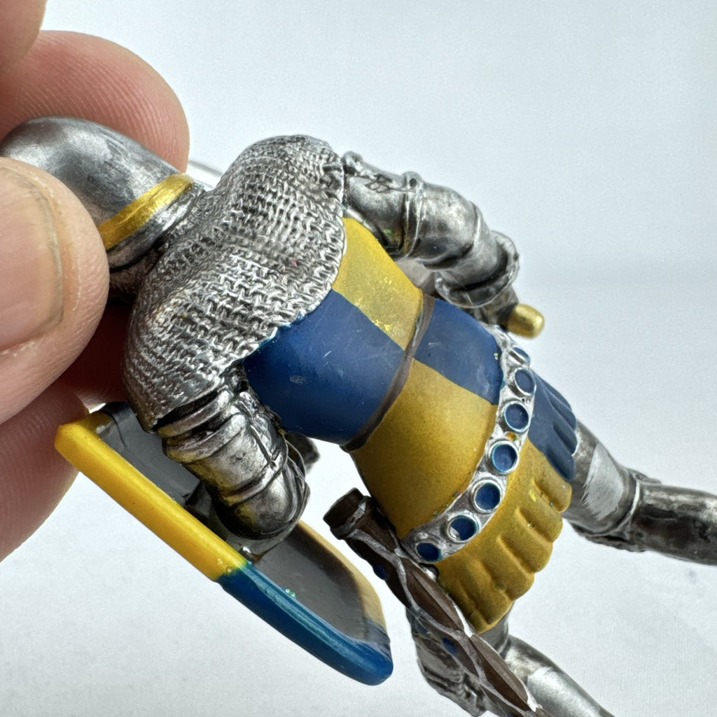 Schleich 2003 medieval knight foot soldier plastic figure holding a sword and blue and yellow lion shield