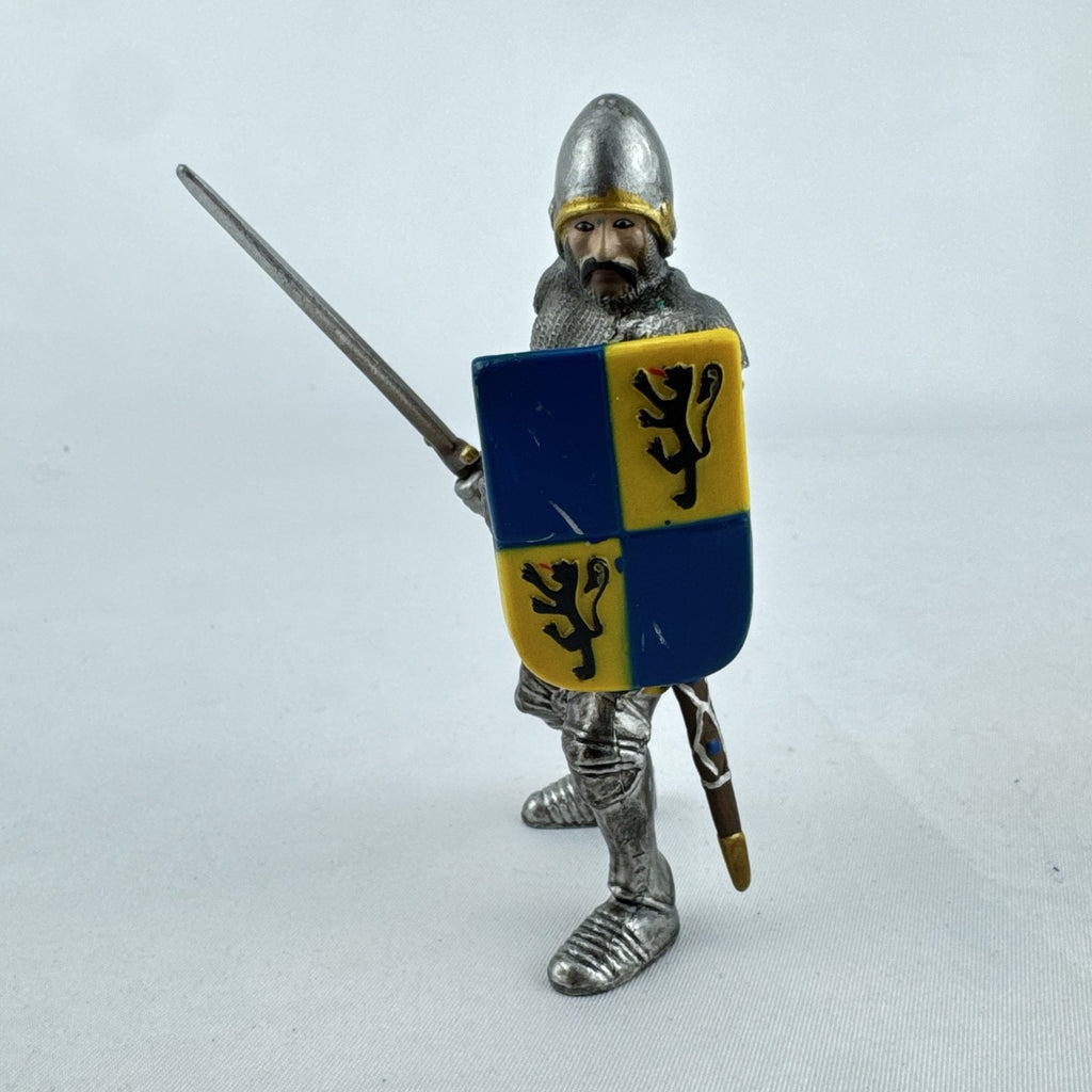 Schleich 2003 medieval knight foot soldier plastic figure holding a sword and blue and yellow lion shield