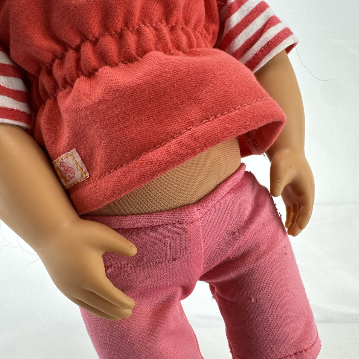 Battat Our Generation 18-inch doll with wavy brown hair, red striped shirt, and pink shorts