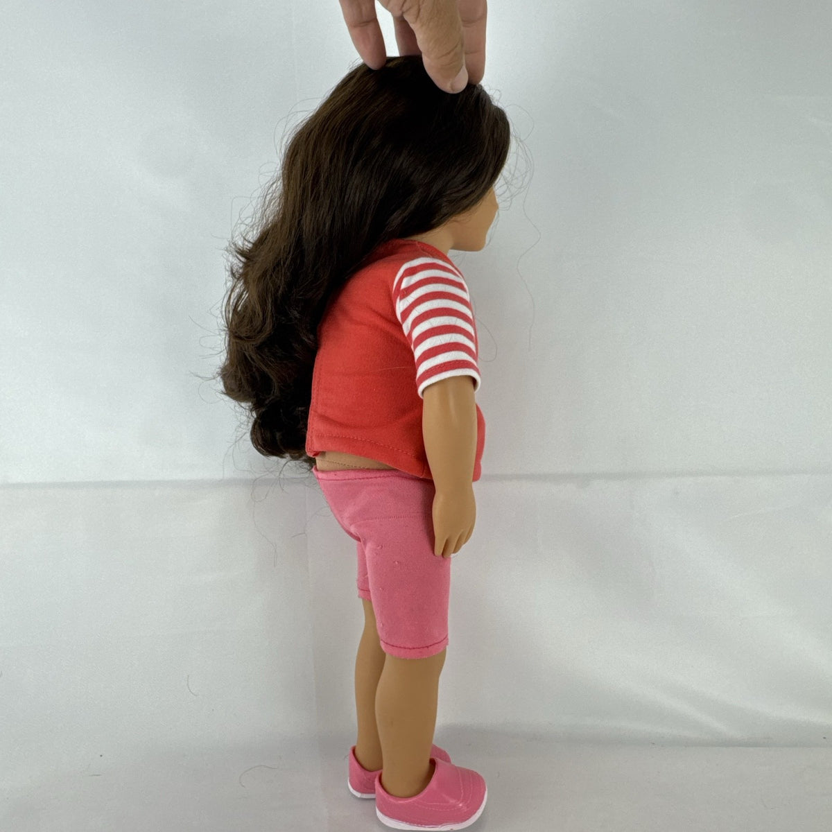 Battat Our Generation 18-inch doll with wavy brown hair, red striped shirt, and pink shorts