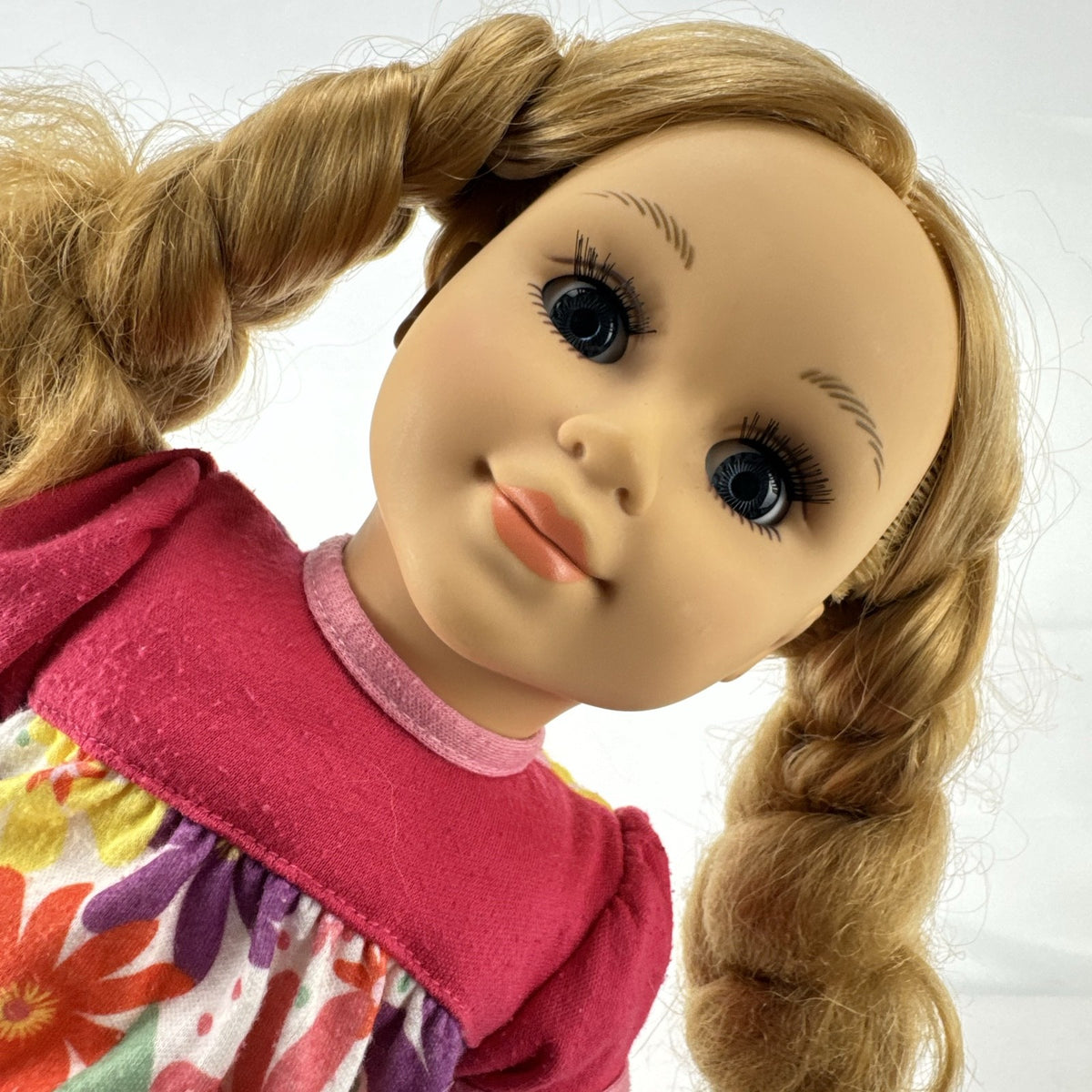 Lovee Doll & Toy Co. 18-inch girl doll with blonde braids, blue eyes, floral top, and pink glitter flats