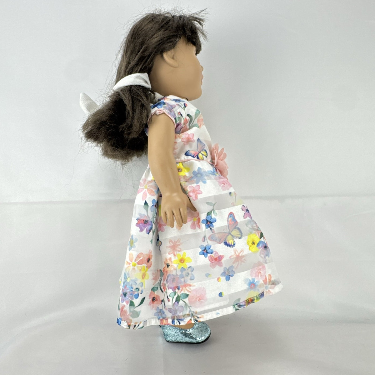 Madame Alexander 18-inch vinyl girl doll with brown ponytail, blue eyes, butterfly floral dress, and glitter shoes