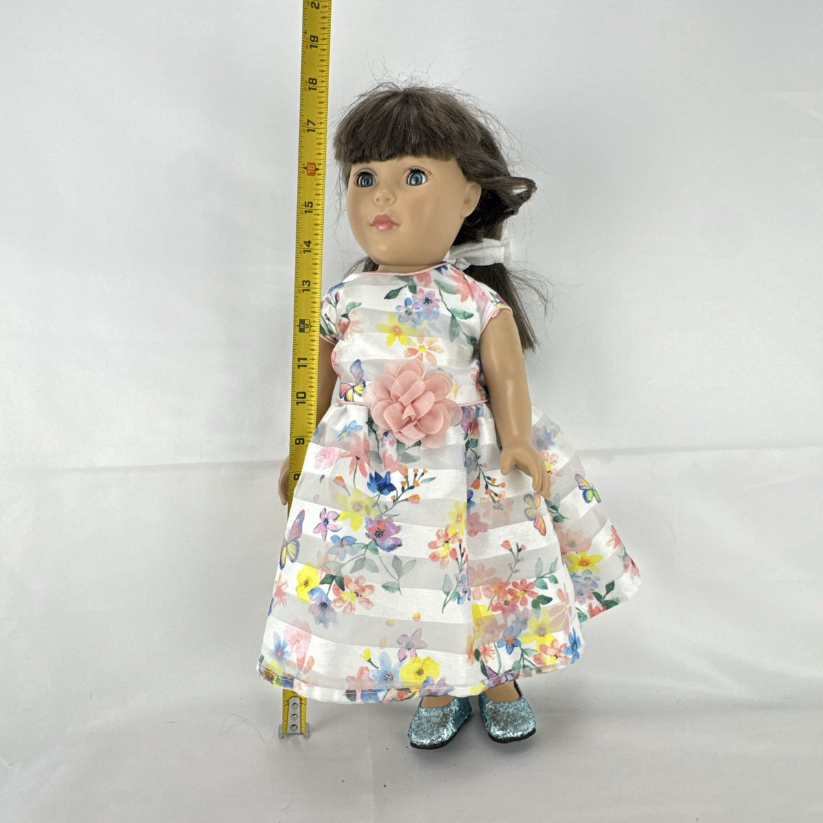 Madame Alexander 18-inch vinyl girl doll with brown ponytail, blue eyes, butterfly floral dress, and glitter shoes