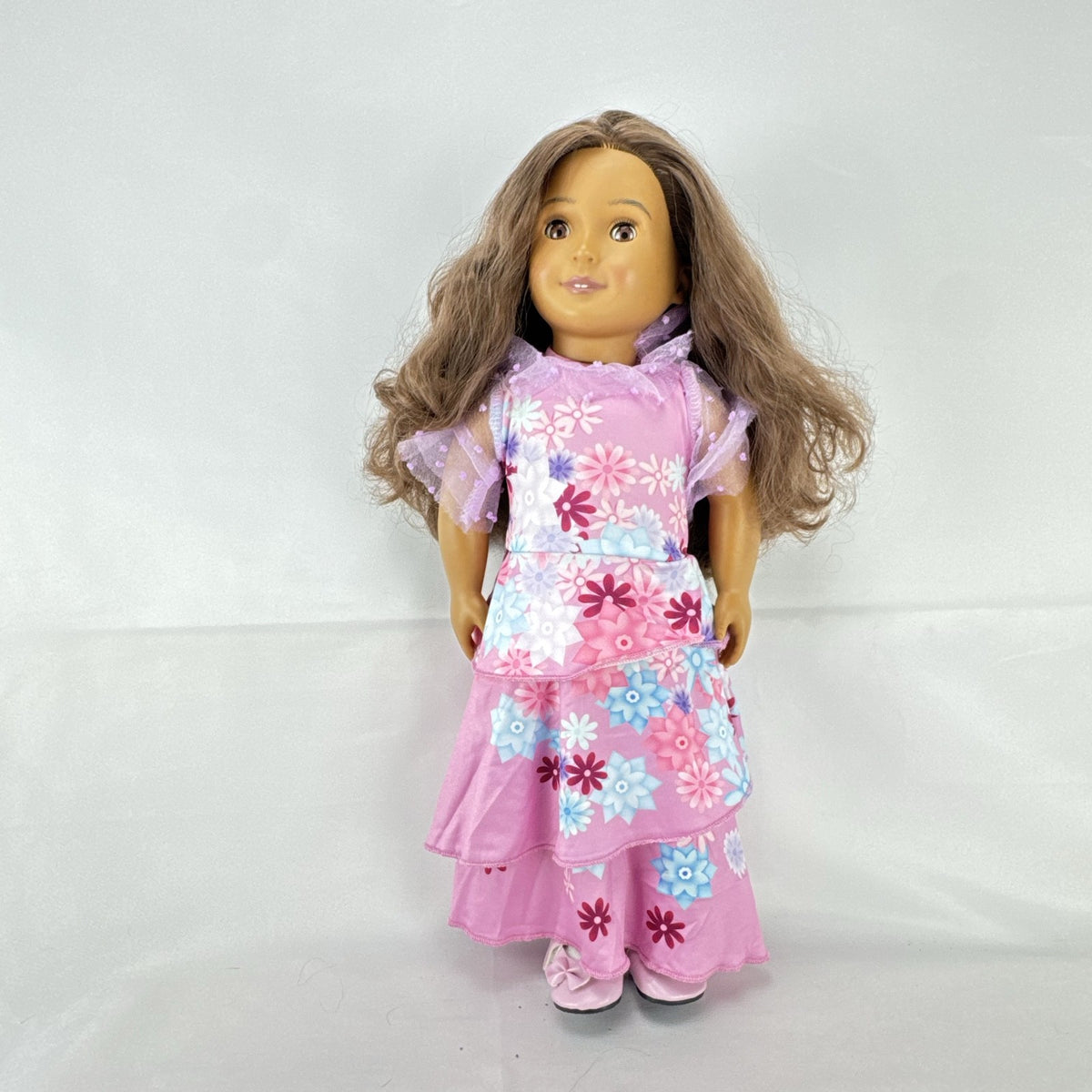 Battat Our Generation 18-inch girl doll with wavy brown hair wearing a pink floral tiered dress and bow shoes