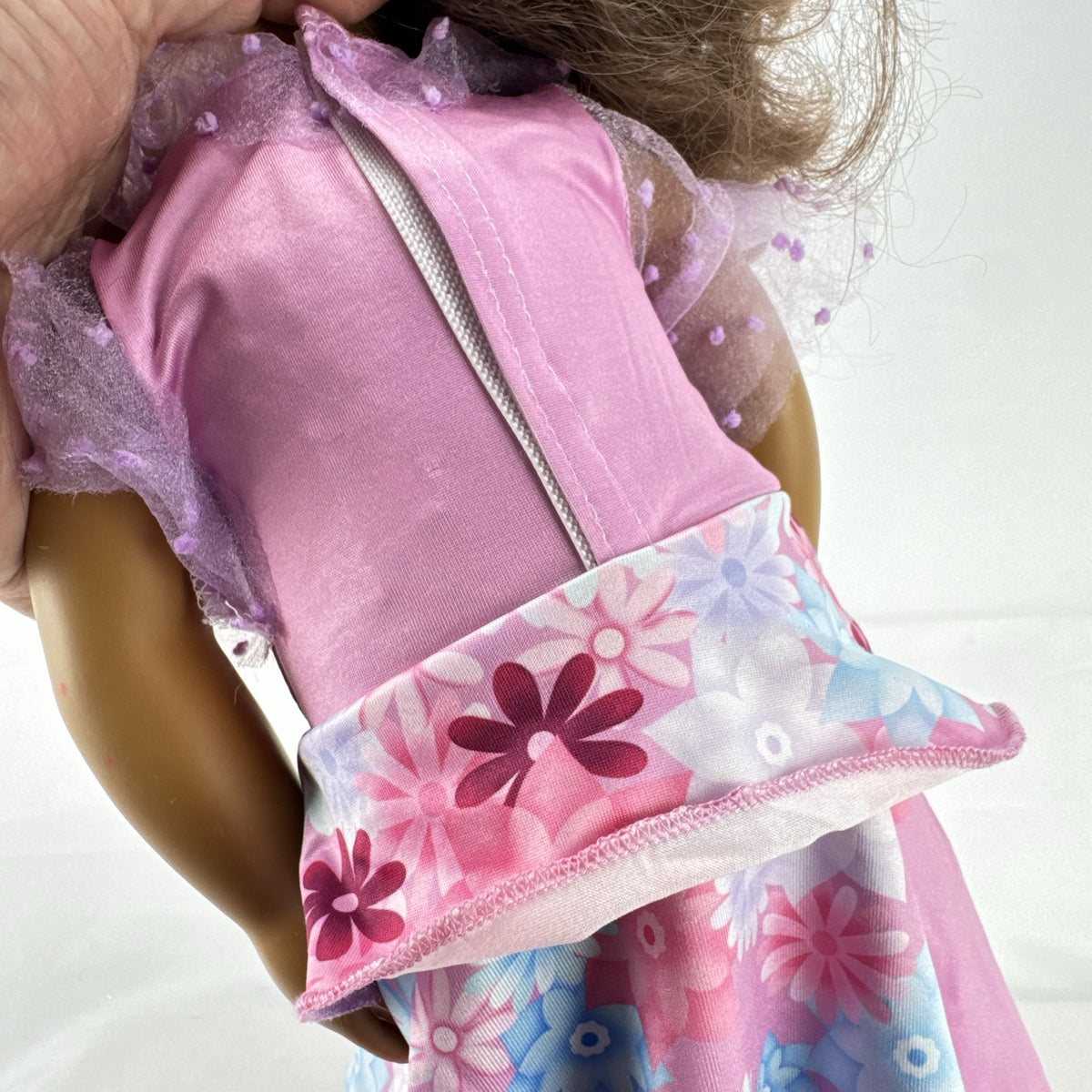 Battat Our Generation 18-inch girl doll with wavy brown hair wearing a pink floral tiered dress and bow shoes