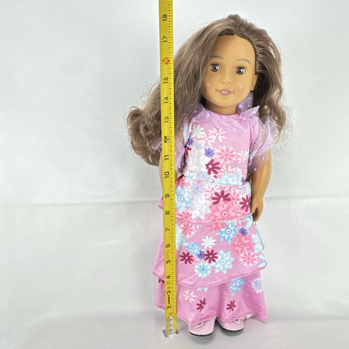 Battat Our Generation 18-inch girl doll with wavy brown hair wearing a pink floral tiered dress and bow shoes