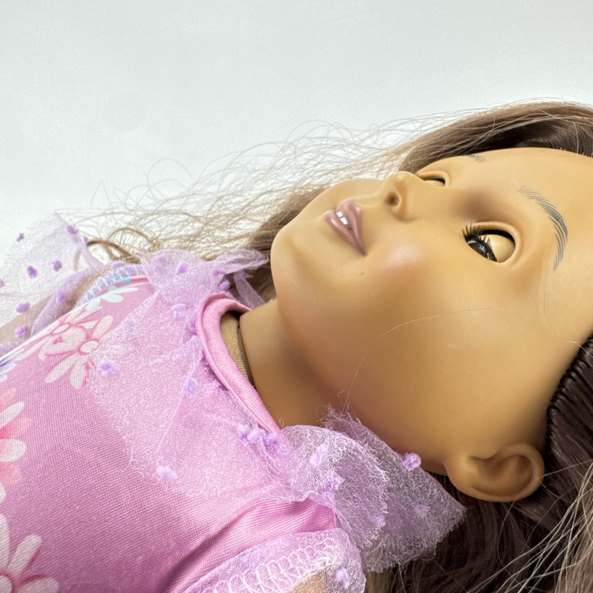 Battat Our Generation 18-inch girl doll with wavy brown hair wearing a pink floral tiered dress and bow shoes