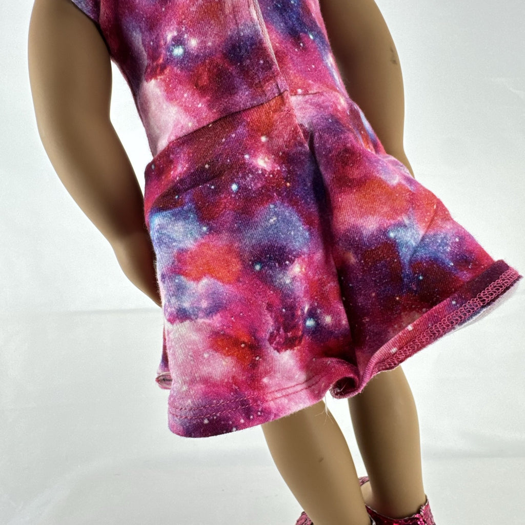 Our Generation 18-inch doll with brown afro puffs wearing a pink galaxy print dress and glitter shoes