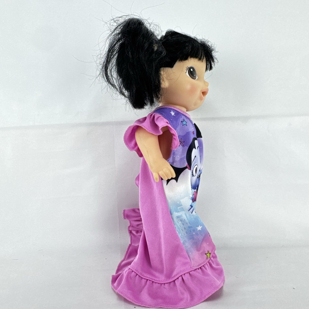 Hasbro Baby Alive 12-inch doll with black pigtails wearing a colorful Disney Vampirina dress