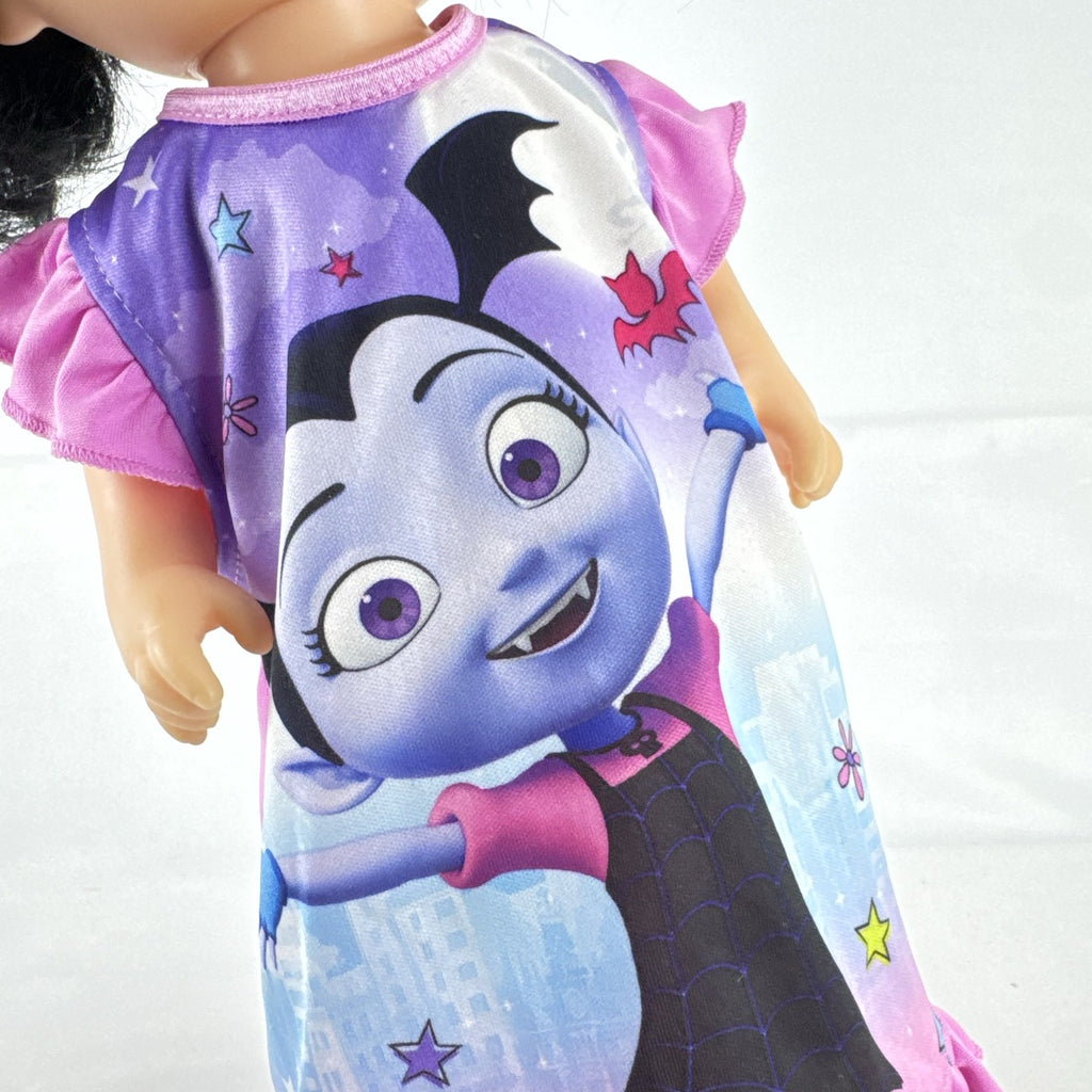 Hasbro Baby Alive 12-inch doll with black pigtails wearing a colorful Disney Vampirina dress