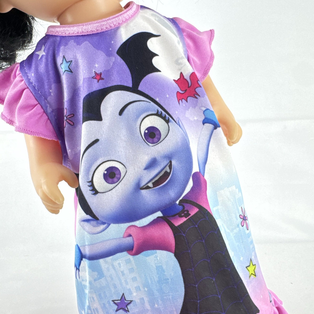 Hasbro Baby Alive 12-inch doll with black pigtails wearing a colorful Disney Vampirina dress