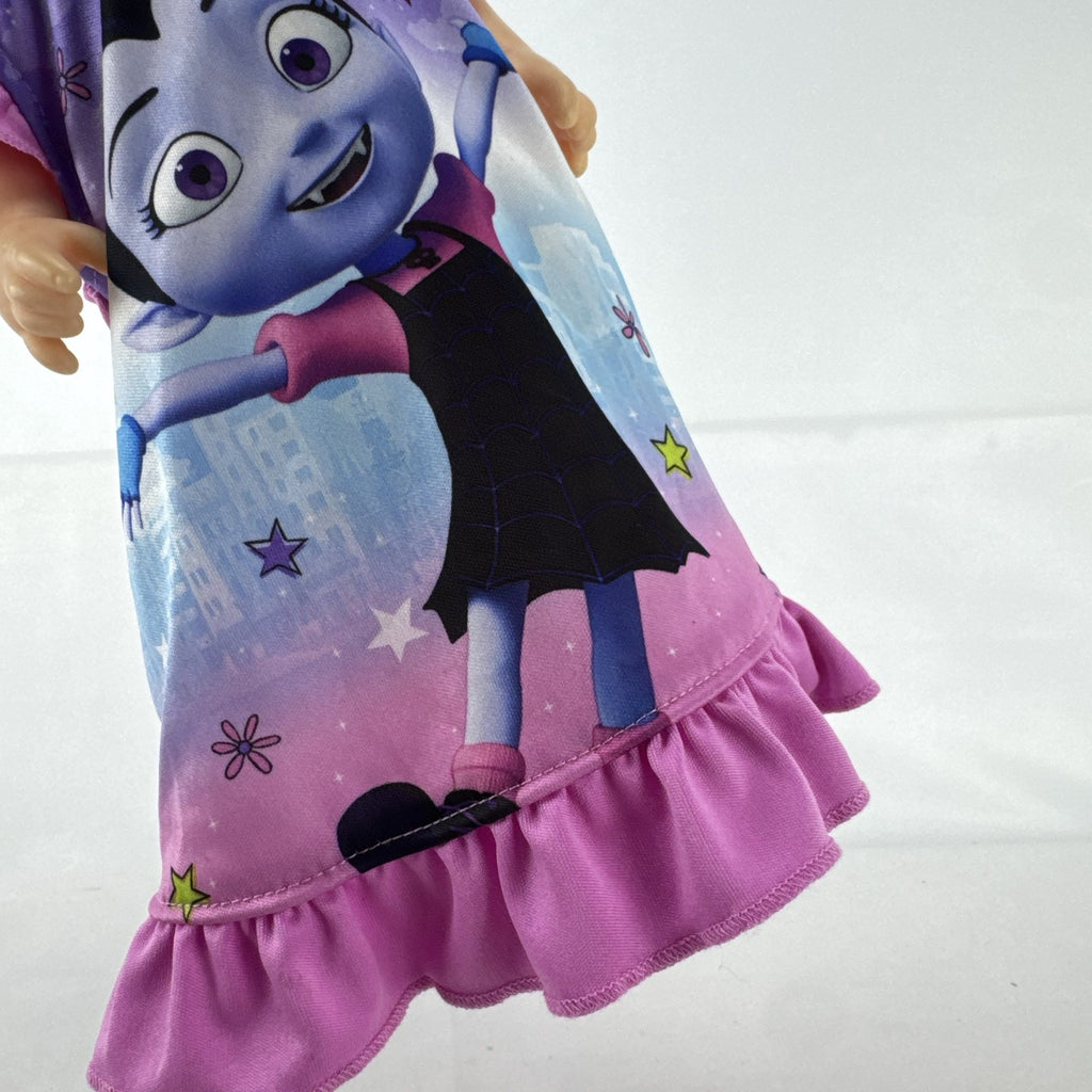 Hasbro Baby Alive 12-inch doll with black pigtails wearing a colorful Disney Vampirina dress