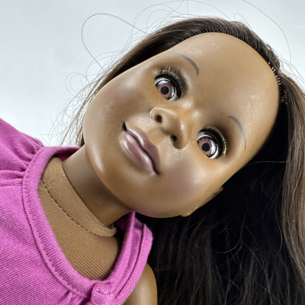 Our Generation 18-inch African American doll in pink wrap top and denim pants with long dark brown hair