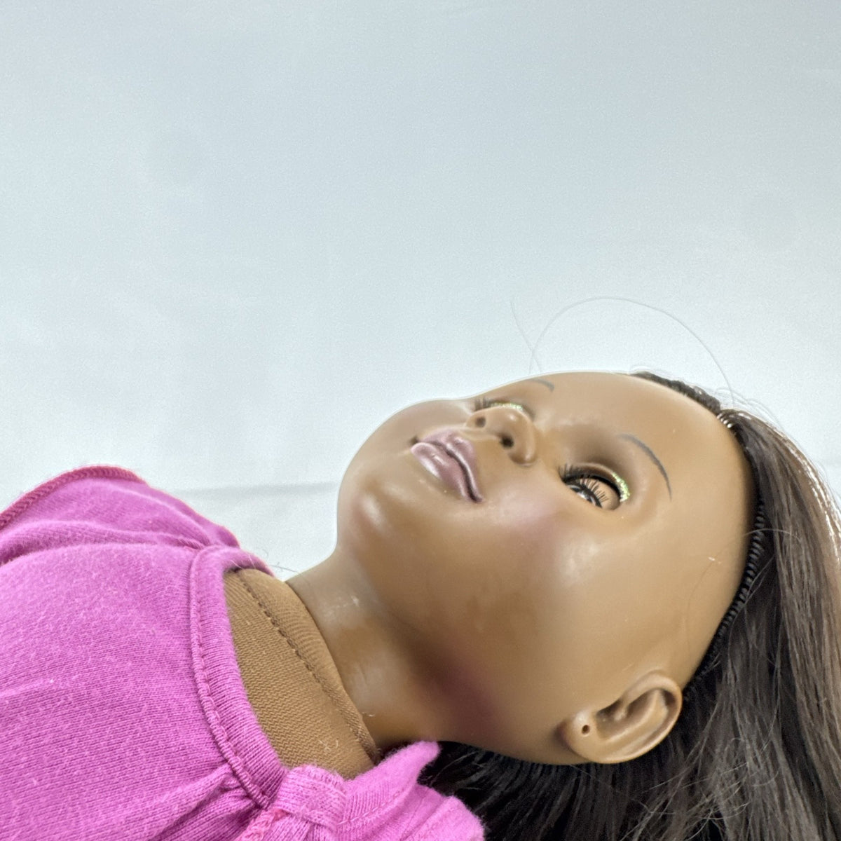 Our Generation 18-inch African American doll in pink wrap top and denim pants with long dark brown hair