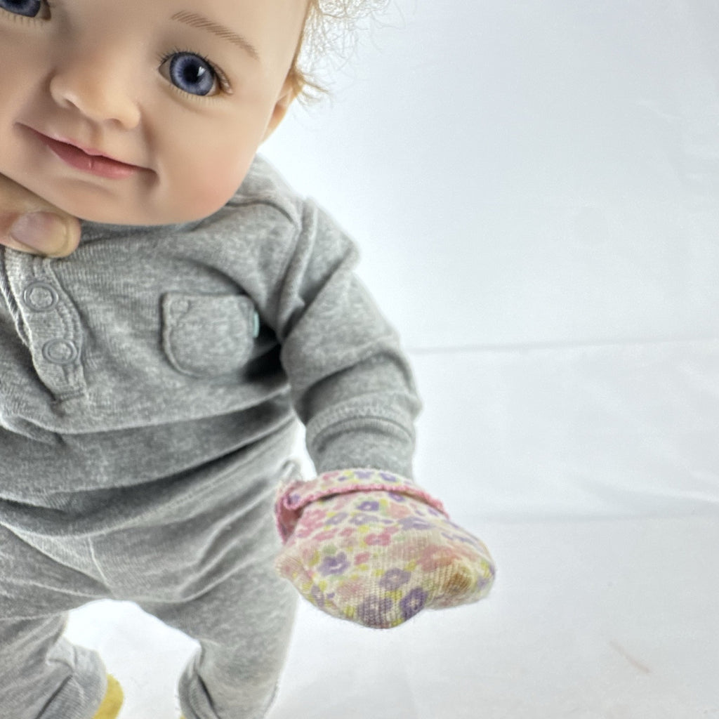 The Ashton-Drake Galleries 16-inch vinyl reborn baby doll sculpted by Ping Lau in grey loungewear
