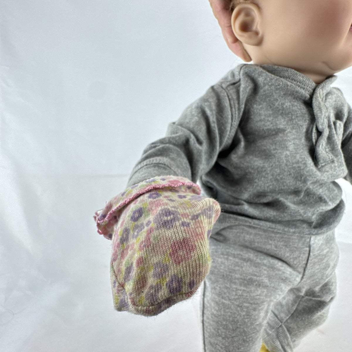 The Ashton-Drake Galleries 16-inch vinyl reborn baby doll sculpted by Ping Lau in grey loungewear