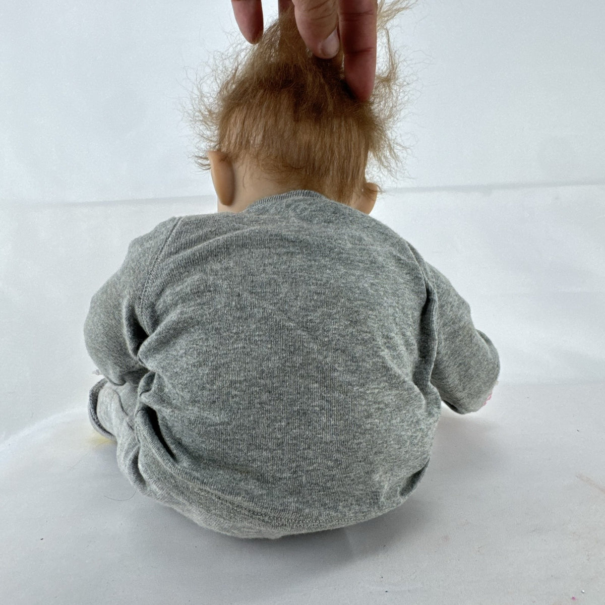 The Ashton-Drake Galleries 16-inch vinyl reborn baby doll sculpted by Ping Lau in grey loungewear