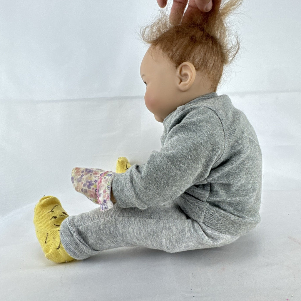 The Ashton-Drake Galleries 16-inch vinyl reborn baby doll sculpted by Ping Lau in grey loungewear