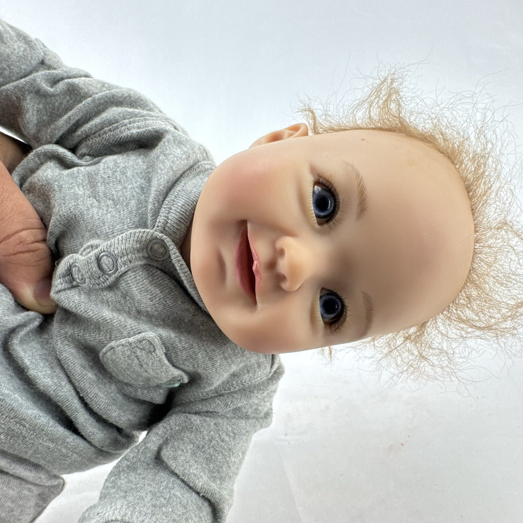 The Ashton-Drake Galleries 16-inch vinyl reborn baby doll sculpted by Ping Lau in grey loungewear