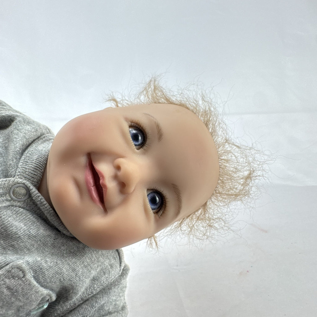 The Ashton-Drake Galleries 16-inch vinyl reborn baby doll sculpted by Ping Lau in grey loungewear