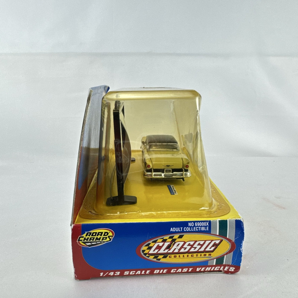 Road Champs 1:43 scale 1957 Ford Fairlane diecast car in yellow and black packaging with display stand