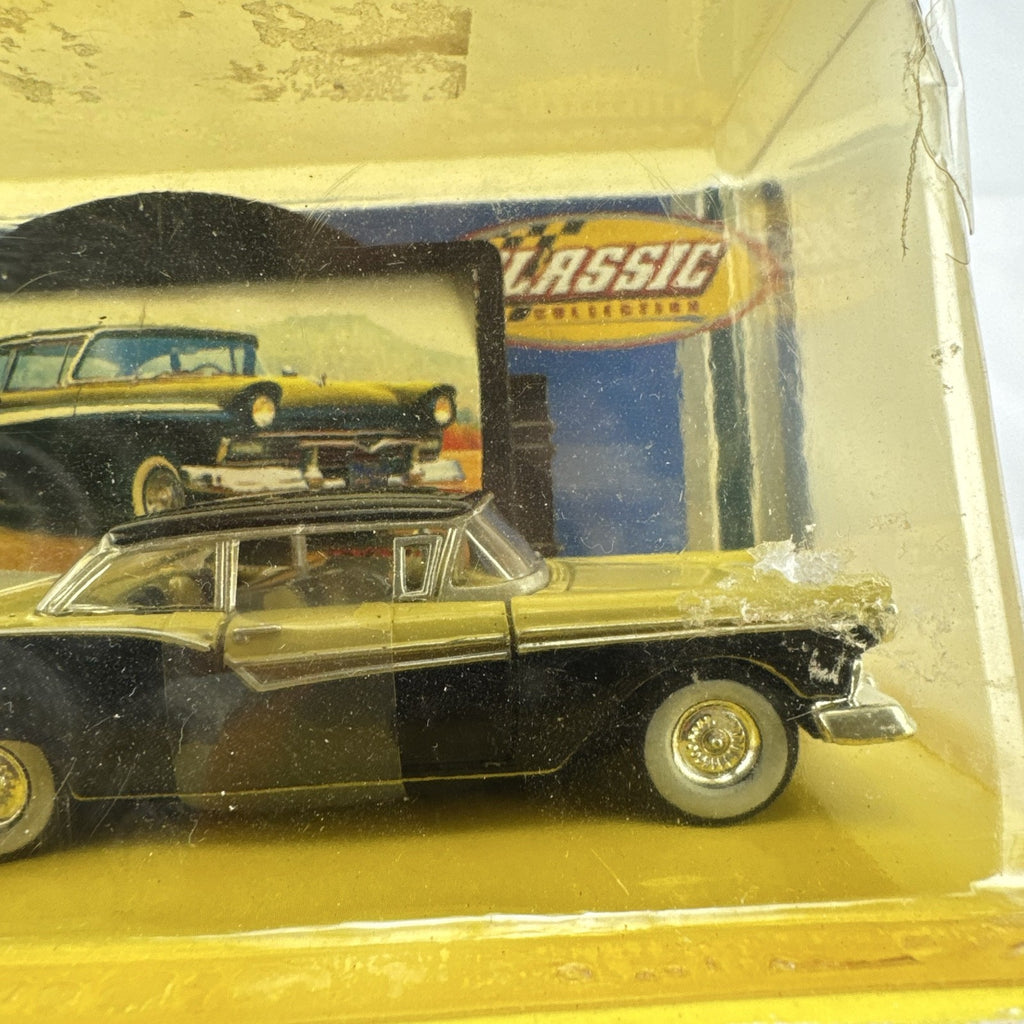 Road Champs 1:43 scale 1957 Ford Fairlane diecast car in yellow and black packaging with display stand