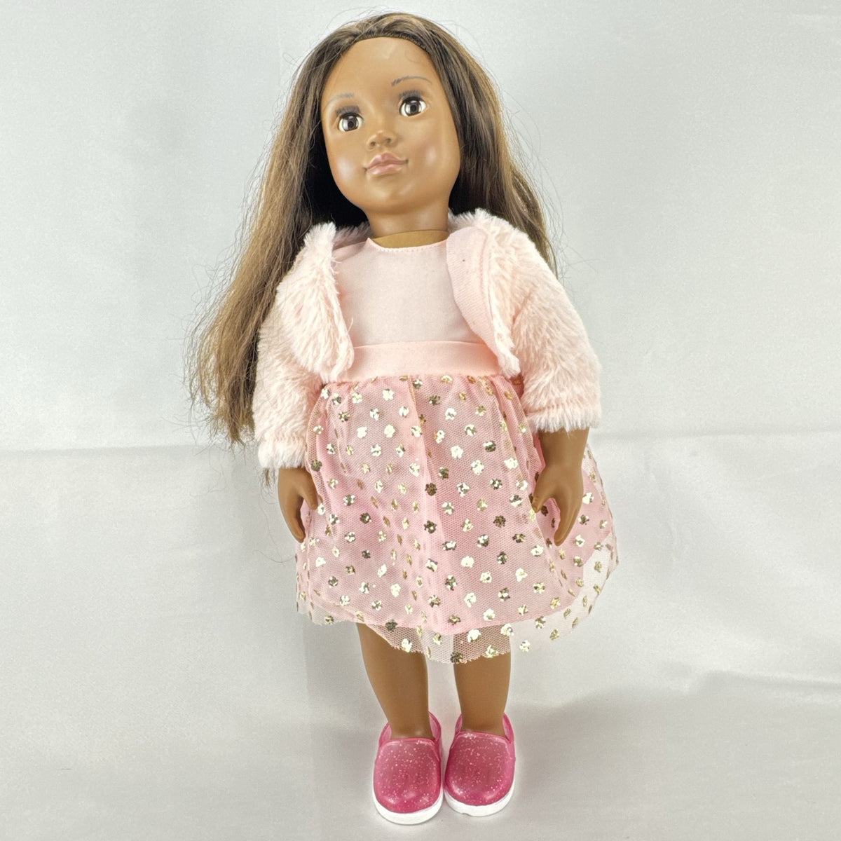 American Girl Truly Me 18-inch doll with dark skin and brown hair wearing a pink sparkle party dress and shrug