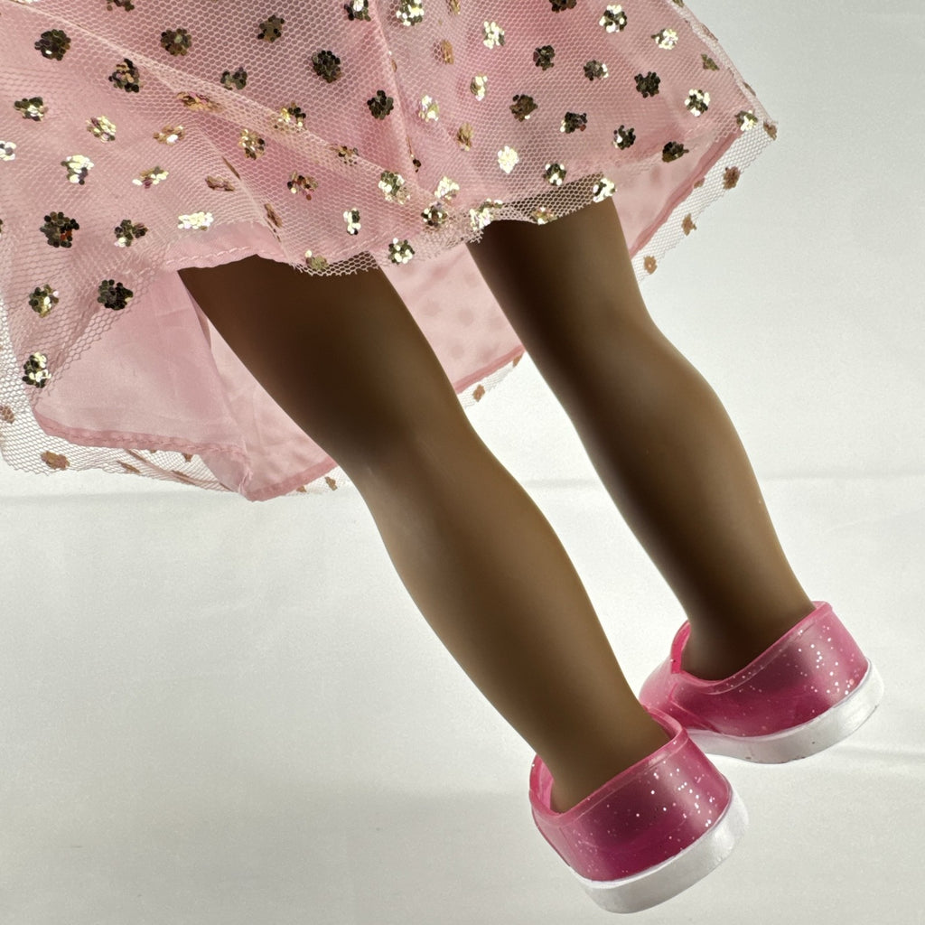 American Girl Truly Me 18-inch doll with dark skin and brown hair wearing a pink sparkle party dress and shrug