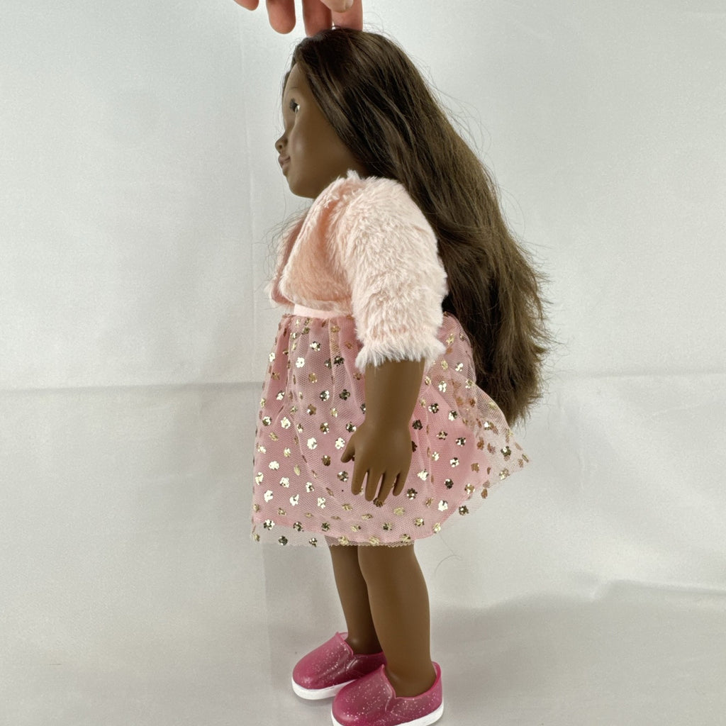 American Girl Truly Me 18-inch doll with dark skin and brown hair wearing a pink sparkle party dress and shrug