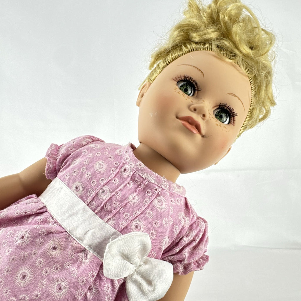 Cititoy 18-inch vinyl girl doll with blonde hair updo, green eyes, freckles, and pink floral outfit with glitter shoes.