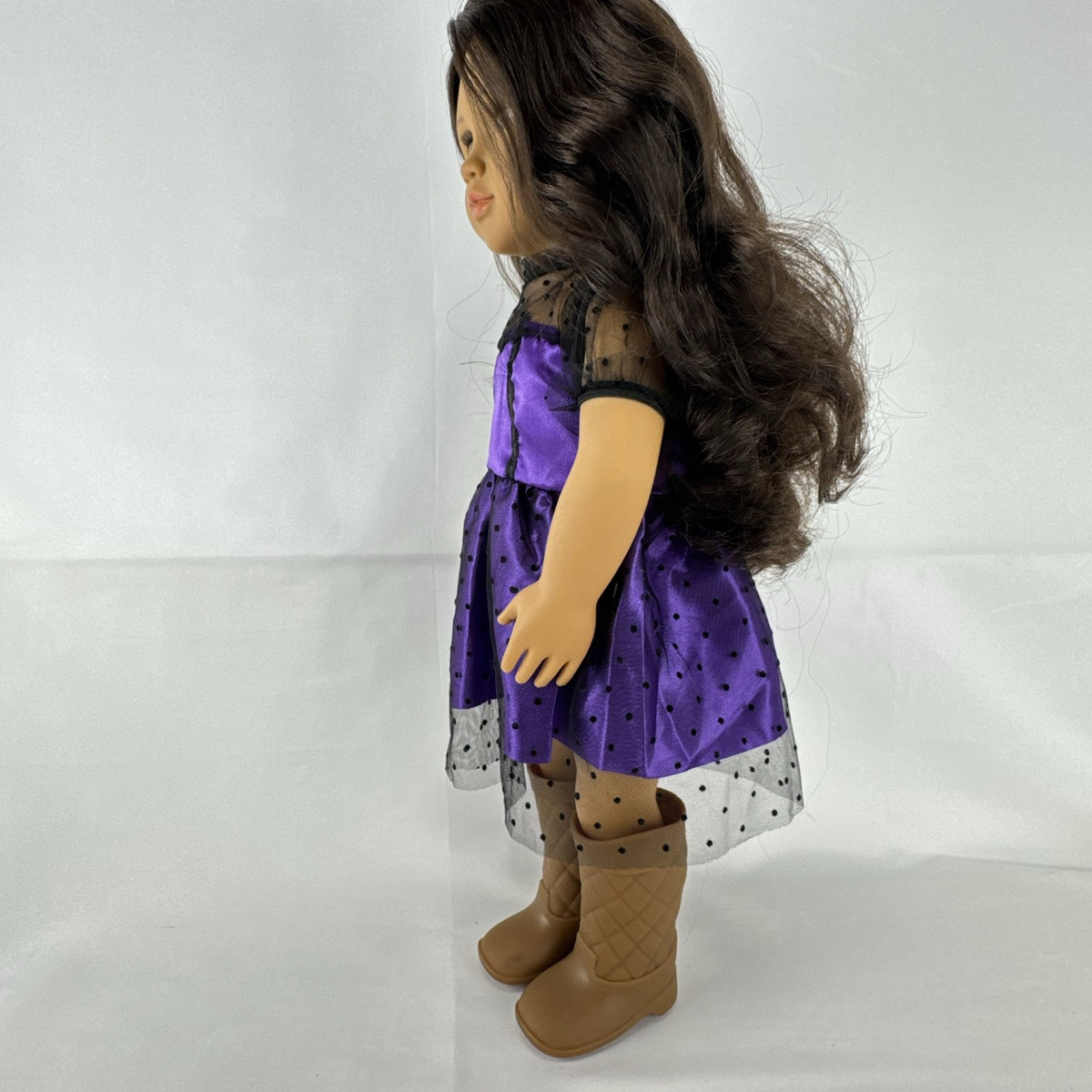 Battat Our Generation 18-inch vinyl doll with wavy dark brown hair, wearing a purple polka-dot dress and tan boots.