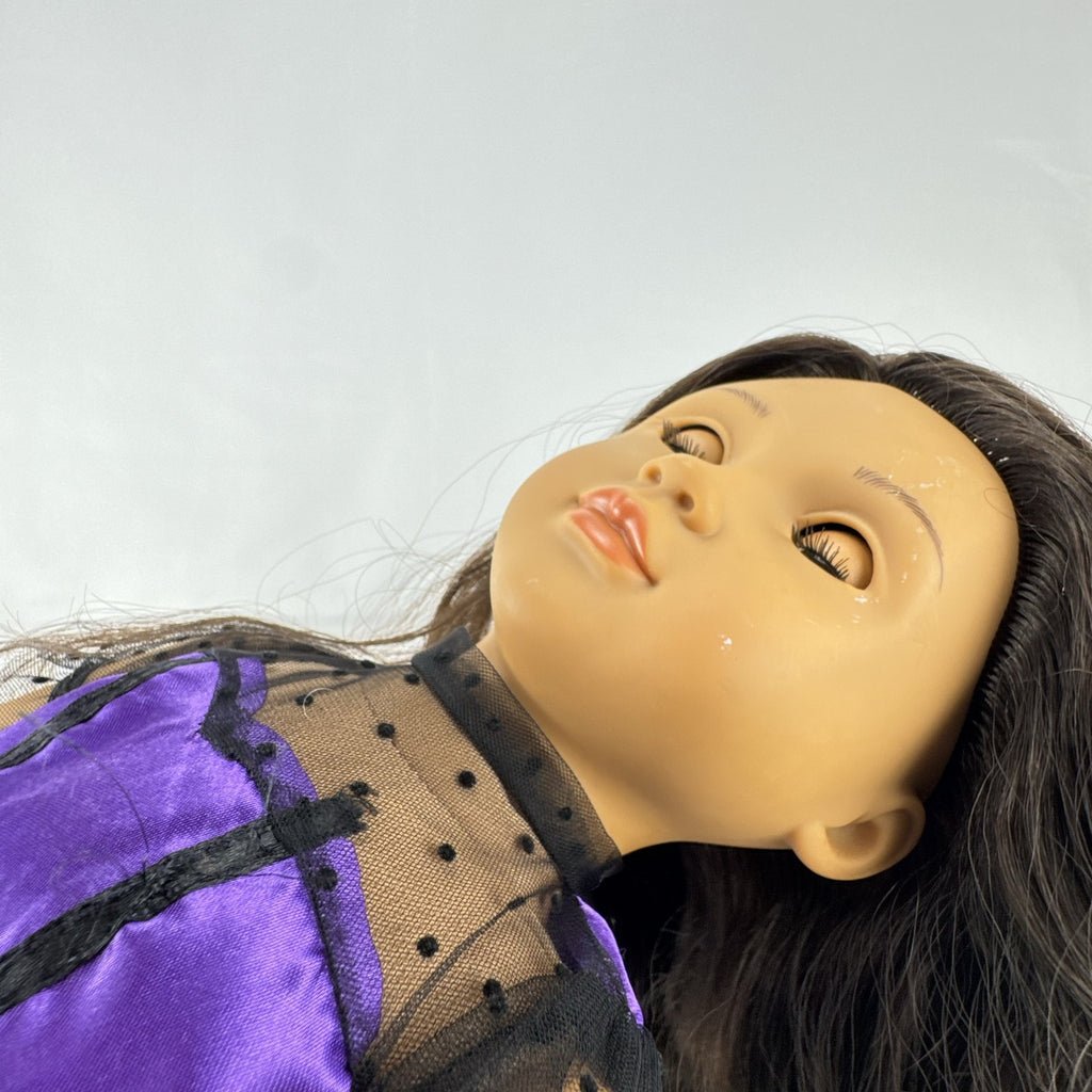 Battat Our Generation 18-inch vinyl doll with wavy dark brown hair, wearing a purple polka-dot dress and tan boots.