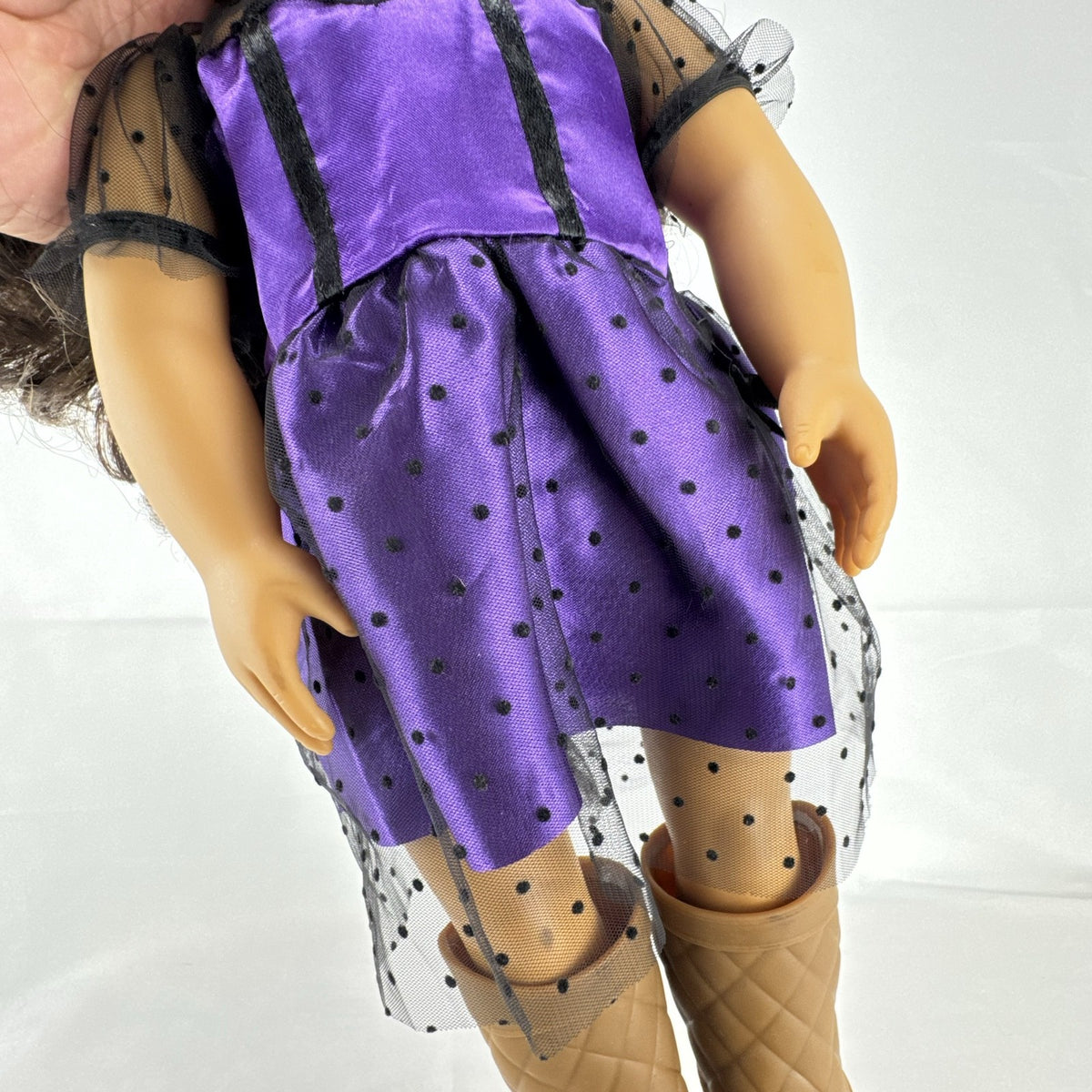Battat Our Generation 18-inch vinyl doll with wavy dark brown hair, wearing a purple polka-dot dress and tan boots.
